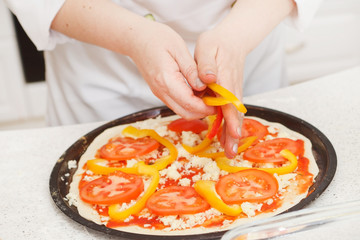 chef making pizza at kitchen