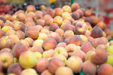 Variety of peaches in boxes in supermarket