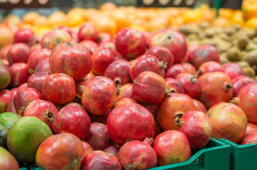 Variety of pomegranate fruits in boxes in supermarket