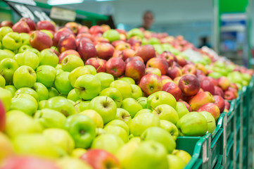 Variety of apples in boxes in supermarket