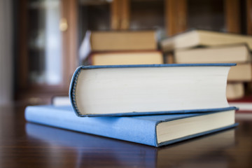 Many different sized colored and shaped books on wood table