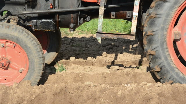 small old tractor planting potatoes