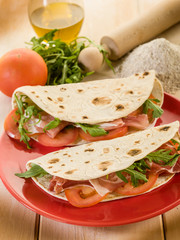 piadina with ham arugula and tomatoes, typical italian sandwich