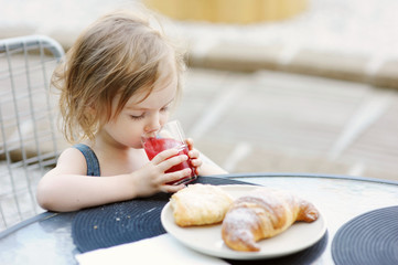 Smiling little girl having breakfast