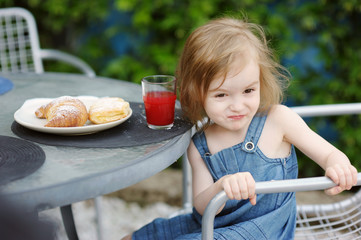 Smiling little girl having breakfast
