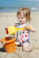 Cute little girl playing with beach toys