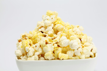 Bowl with popcorn on white background