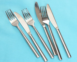 Forks and knives on a blue tablecloth