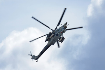 The fighting helicopter against the blue sky