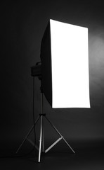 Studio flash with soft-box on black studio background