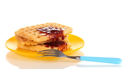 Tasty waffles with jam on plate isolated on white