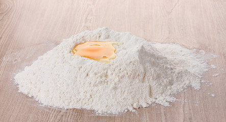 egg in flour on wooden table