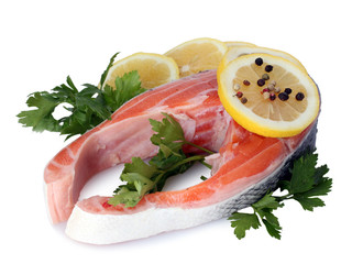 Red fish with lemon, parsley and pepper isolated on white.