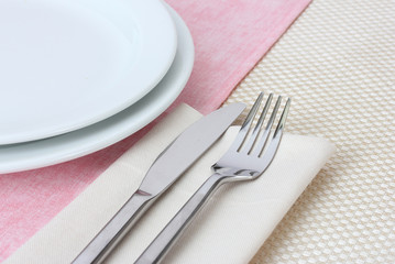 Table setting with fork, knife, plates, and napkin