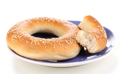 Whole bagel with bit on plate isolated on white