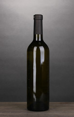 Bottle of great wine on wooden table on grey background