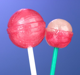 Bright and delicious lollipops on dark blue background close-up