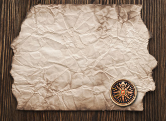 old paper and compass on a wooden background