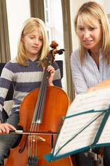 Girl playing cello in music lesson © Monkey Business