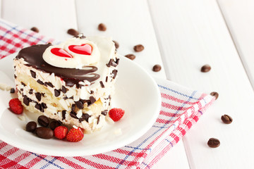 sweet cake with chocolate on plate on wooden table