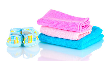 Obraz na płótnie Canvas Blue baby booties and three colorful towels isolated on white