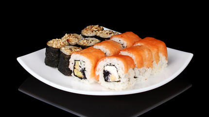Tasty rolls served on white plate isolated on black