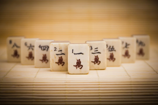 Old chinese game mahjongg on bamboo mat background