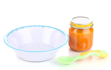 Jar of baby puree with plate and spoon isolated on white
