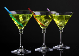 Yellow cocktail in martini glasses isolated on black
