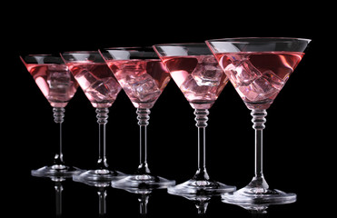 Red cocktail in martini glasses isolated on black
