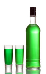 bottle and two glasses of absinthe isolated on white