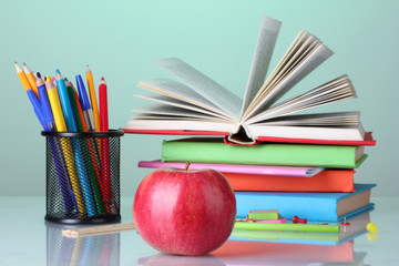 Composition of books, stationery and an apple