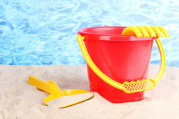 Children's beach toys on sand on water background