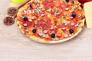 delicious pizza and vegetables on wooden table