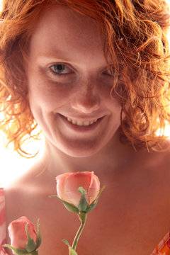 Eine rothaarige Frau mit rosa Rose