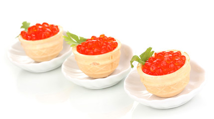 Red caviar in tartlets on little white saucers isolated on white