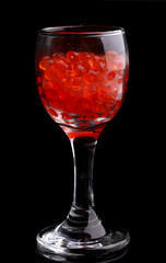 Red caviar in glass isolated on black