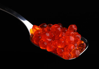 Red caviar in silver spoon isolated on white