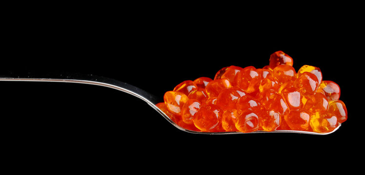 Red caviar in silver spoon isolated on white