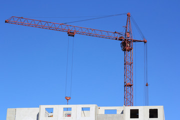 Obraz na płótnie Canvas red crane and blue sky on building site