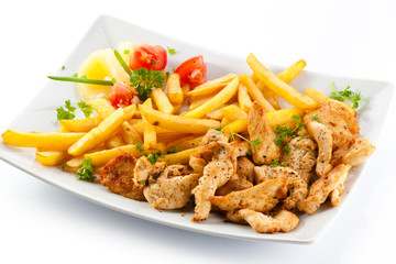 Grilled meat French fries and vegetables on white background
