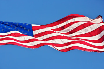 American flag flutters in blue skies