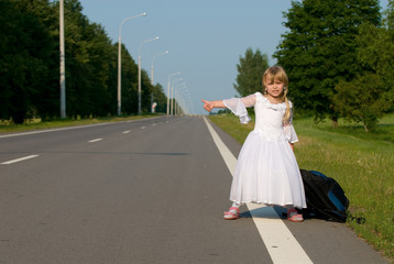 Obraz premium A girl with backpack on the road looking for car