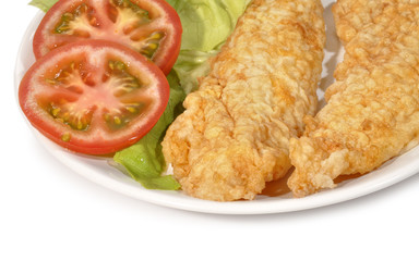 Lomos de merluza rebozados con lechuga y tomate.