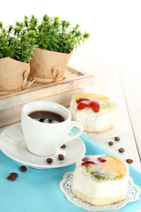 cup of coffee and sweet cakes with fruits on wooden table