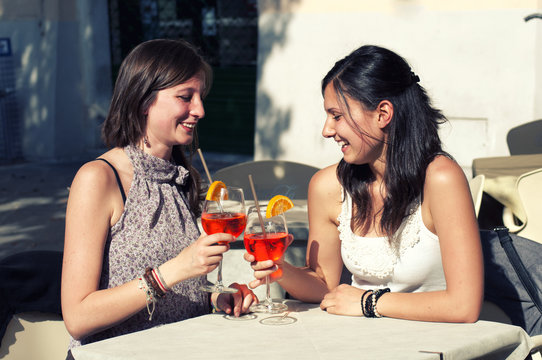 two young girls while they take a cocktail