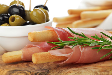 Grissinis mit rohem Schinken und Oliven