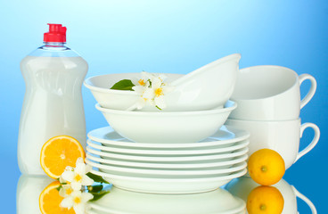 empty clean plates and cups with dishwashing liquid and lemon