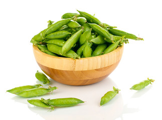 Green peas in wooden bowl isolated on white