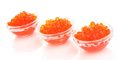 Red caviar in glass bowls isolated on white